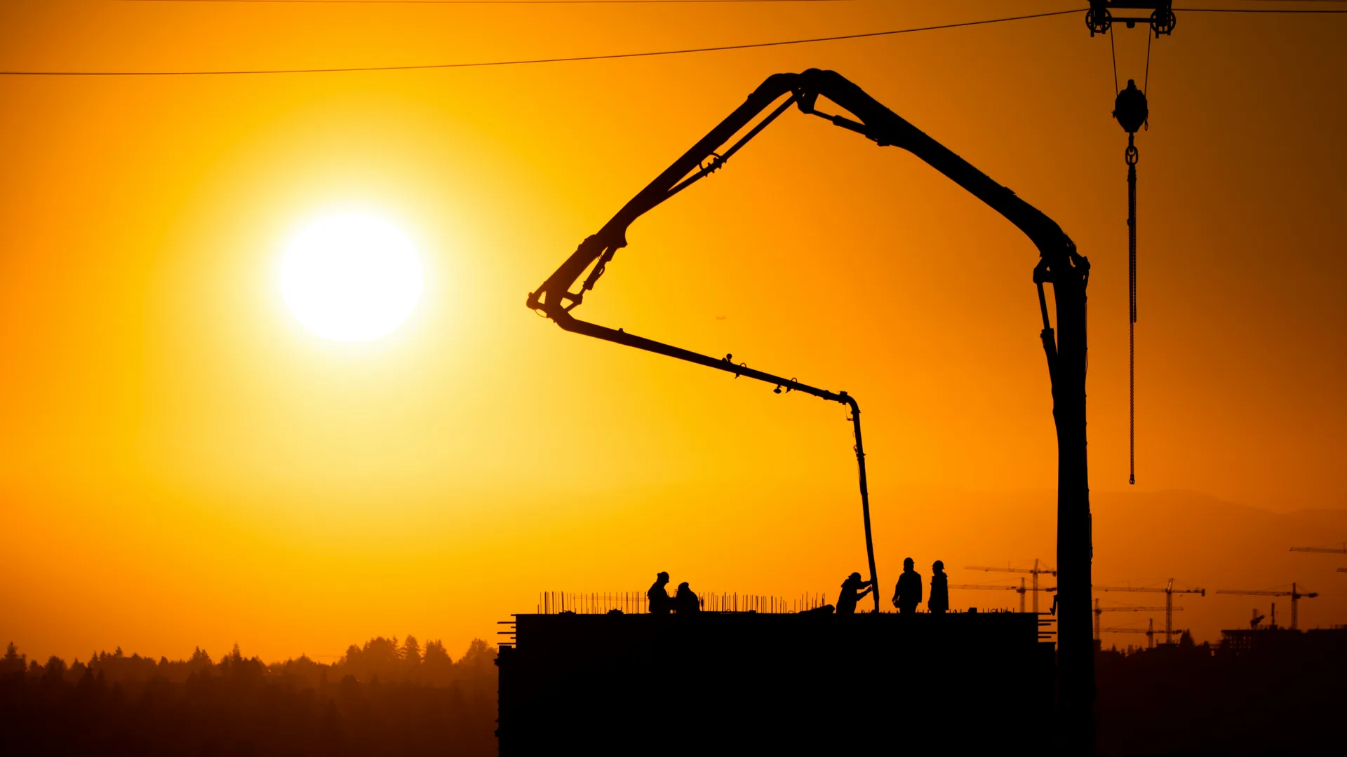 concrete boom pump on a Pittsburgh construction site at sunset