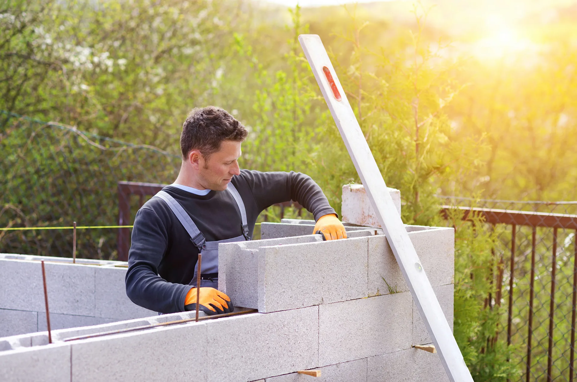 mason levelling a block retaining wall at a Pittsburgh property