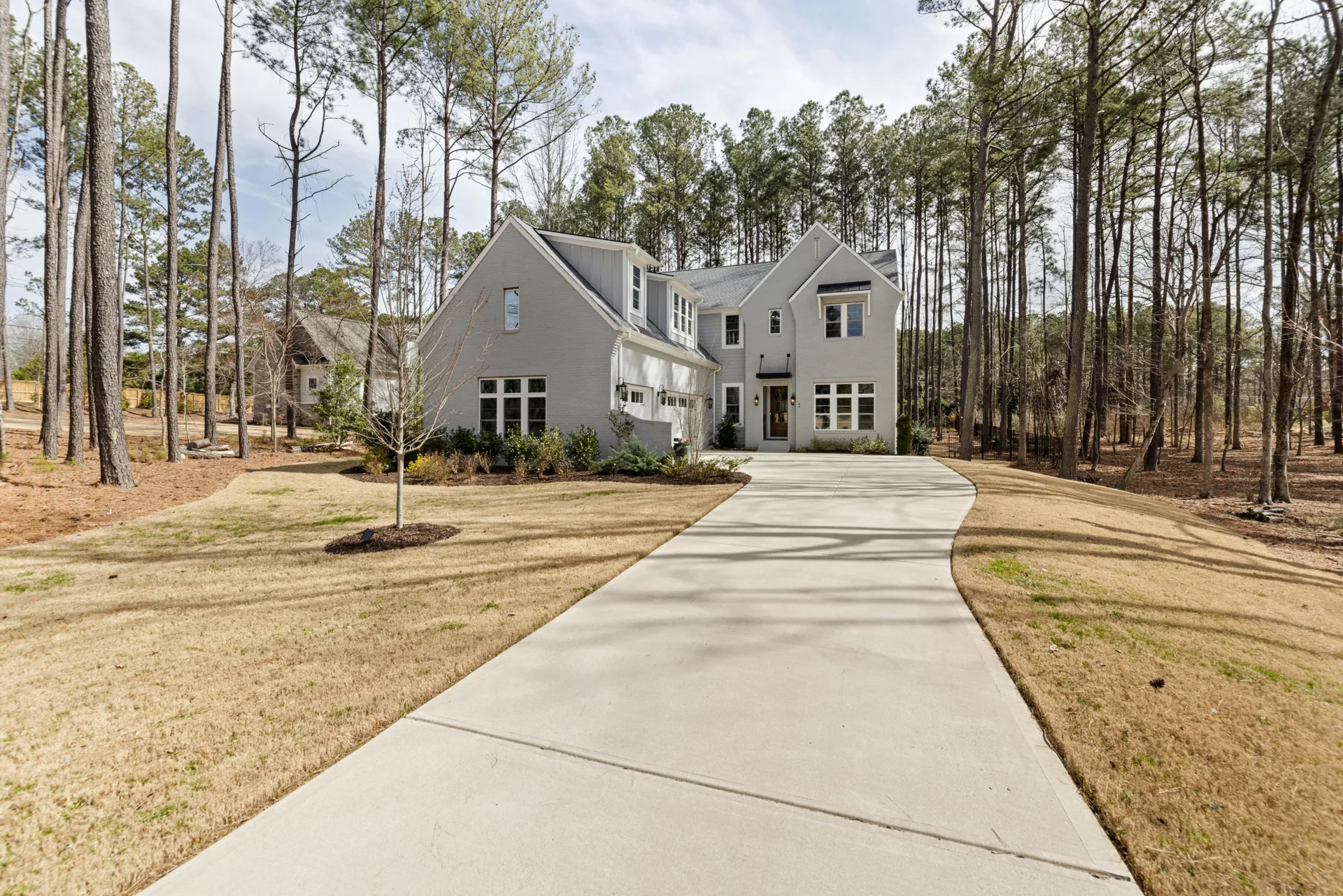 long curving concrete driveway through pines near Beaver